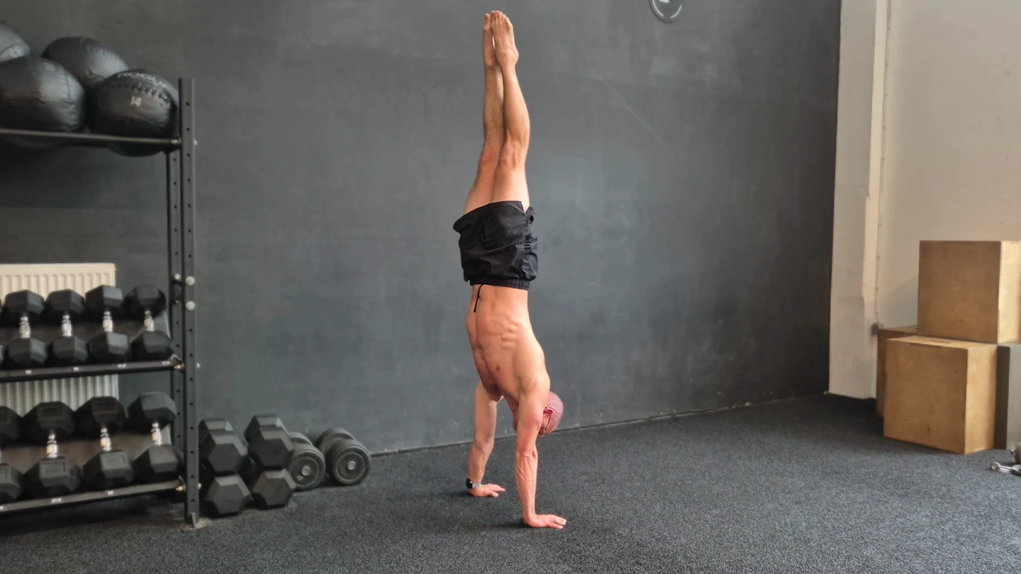 Bene hält einen freien Handstand im Trainingsraum