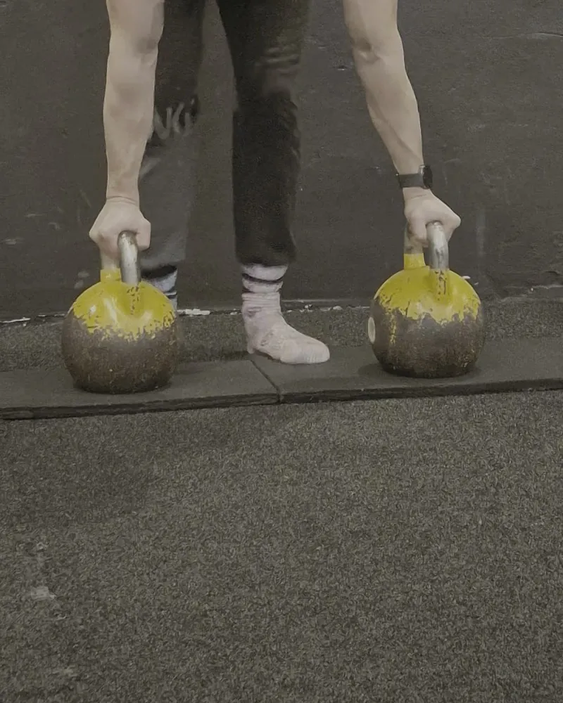 Hände an Kettlebell-Griffen